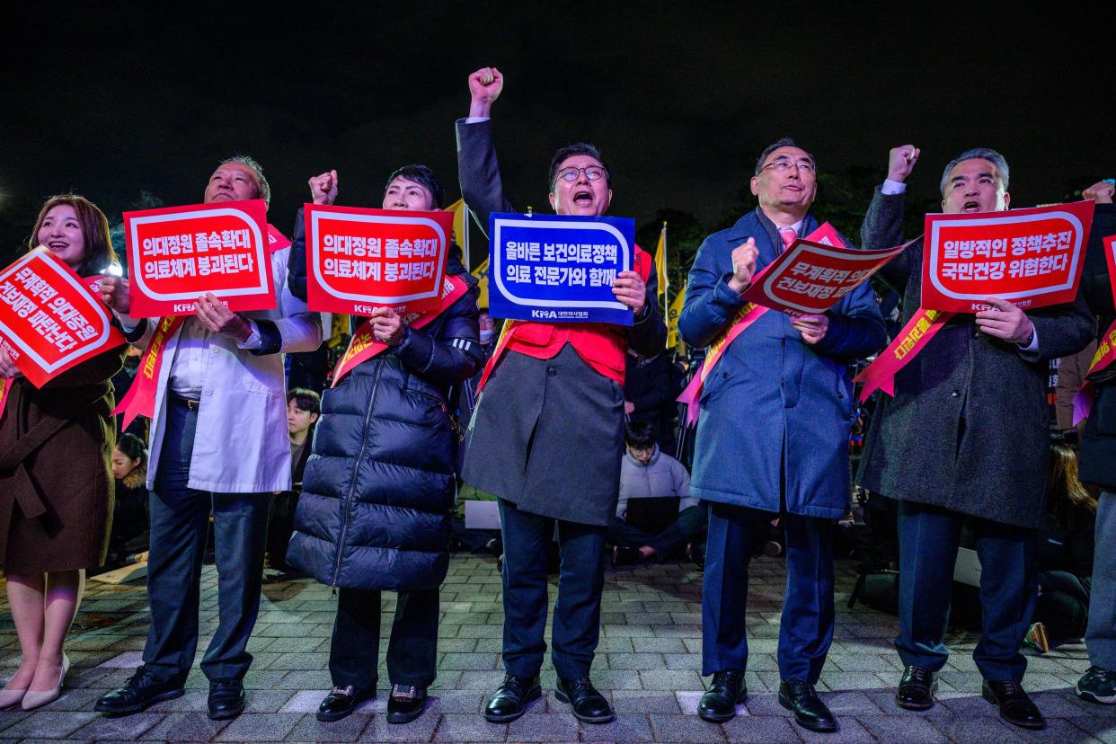 Doctors hold placards that read 'Opposition to the increase in medical schools' as they gather to protest against the government's plan to raise the annual enrolment quota at medical schools by 2000 in Seoul on February 15, 2024.