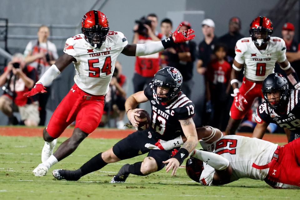 Texas Tech defensive ends Bryce Ramirez (54) and Tyree Wilson (19) team up to trap North Carolina State quarterback Devin Leary (13) during a non-conference game Sept. 17, 2022 in Raleigh. Ramirez suffered a devastating lower-leg injury on the next series.