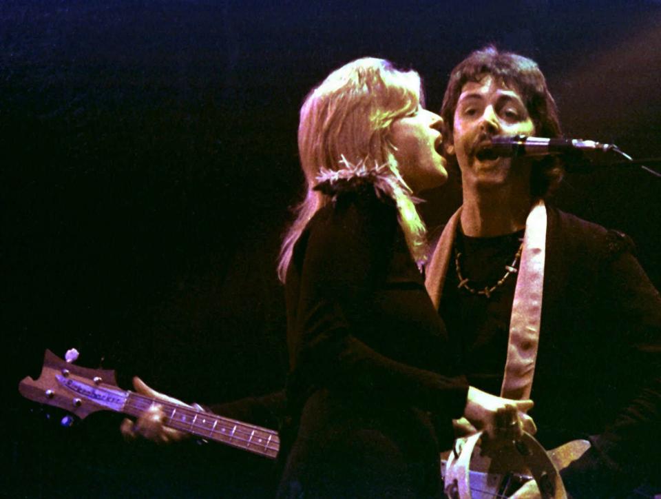 Paul and Linda McCartney perform during a Wings show in London in October 1976.