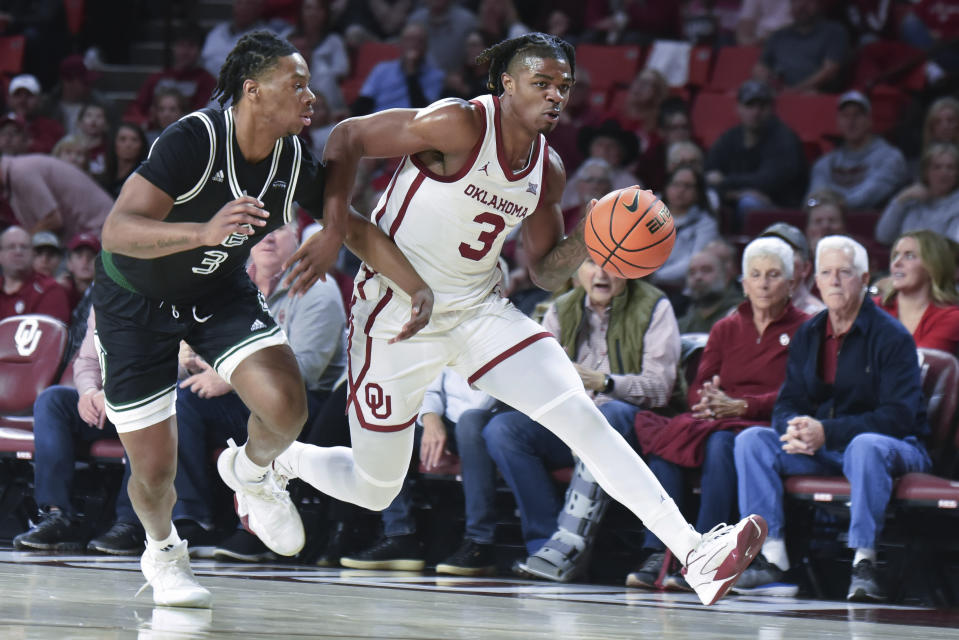 Oklahoma guard Otega Oweh, right, pushes past Green Bay forward Clarence Cummings III during the first half of an NCAA college basketball game, Saturday, Dec. 16, 2023, in Norman, Okla. (AP Photo/Kyle Phillips)