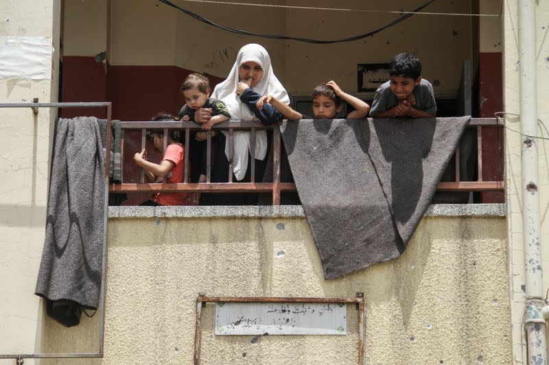 Palestinians inspect the site of an Israeli strike on a school sheltering displaced people, in Gaza City