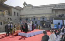 Pope Francis, surrounded by shells of destroyed churches, attends a prayer for the victims of war at Hosh al-Bieaa Church Square, in Mosul, Iraq, once the de-facto capital of IS, Sunday, March 7, 2021. The long 2014-2017 war to drive IS out left ransacked homes and charred or pulverized buildings around the north of Iraq, all sites Francis visited on Sunday. (AP Photo/Andrew Medichini)