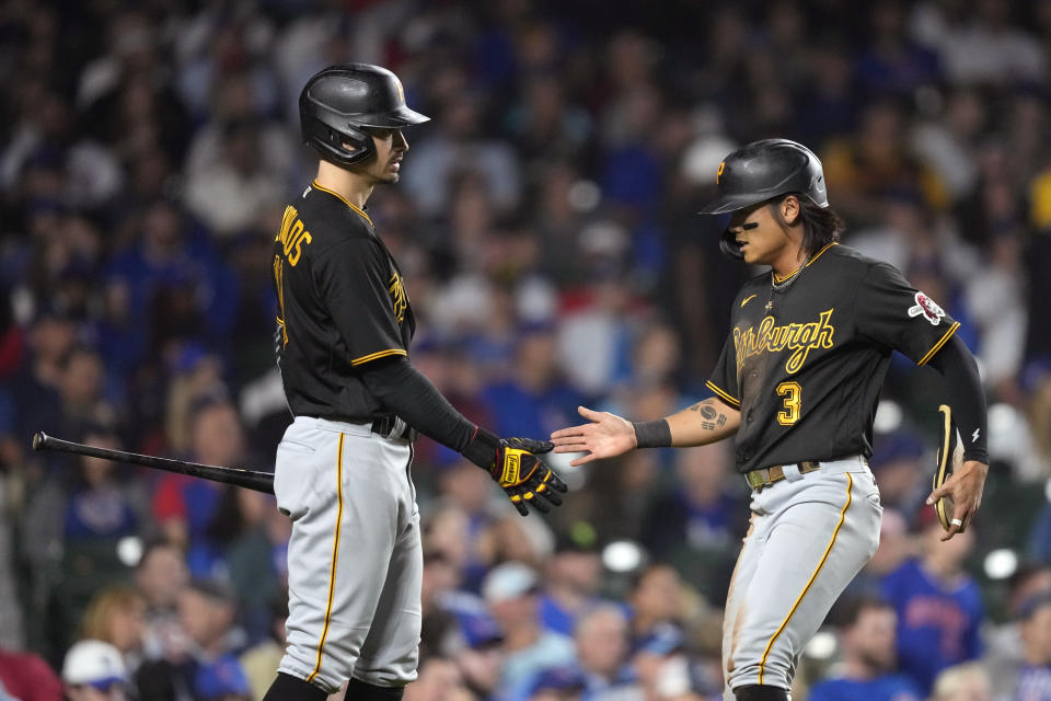 Pittsburgh Pirates' Bryan Reynolds, left, greets Ji Hwan Bae at home after Bae scored on Connor Joe's single against the Chicago Cubs during the eighth inning of a baseball game Thursday, Sept. 21, 2023, in Chicago. (AP Photo/Charles Rex Arbogast)