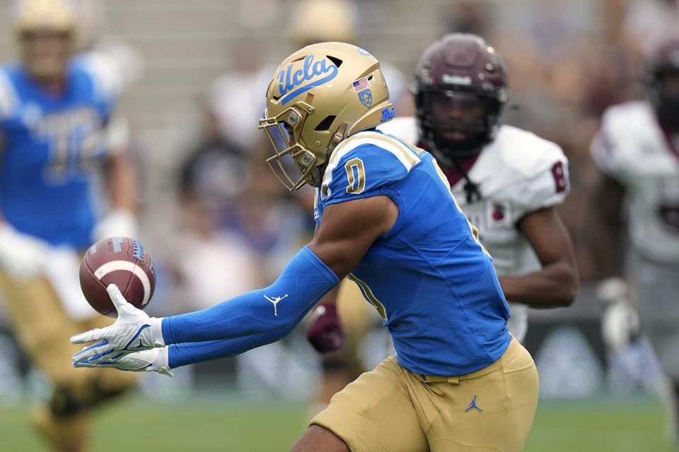 UCLA quarterback Dante Moore, left, makes a catch before running it in for a touchdown as North Carolina Central defensive back Khalil Baker watches during the first half of an NCAA college football game Saturday, Sept. 16, 2023, in Pasadena, Calif. (AP Photo/Mark J. Terrill)