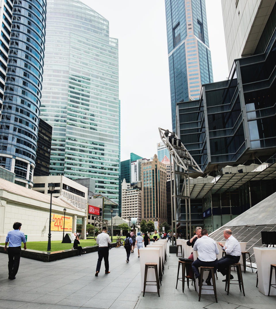 Men eat a business lunch in a street cafe at the Raffles Place, Central Business District of Singapore, illustrating a story on income tax.