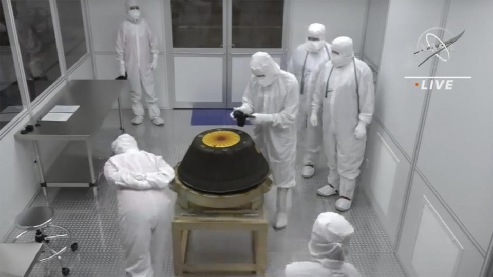 In this image from video provided by NASA, technicians in a clean room examine the sample return capsule from NASA's Osiris-Rex mission after it landed at the Department of Defense's Utah Test and Training Range on Sunday, Sept. 24, 2023. The sample was collected from the asteroid Bennu in October 2020. (NASA via AP)