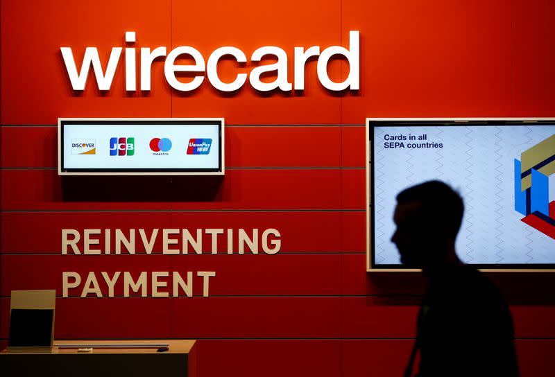 FILE PHOTO: A man walks past the Wirecard booth at the computer games fair Gamescom in Cologne, Germany