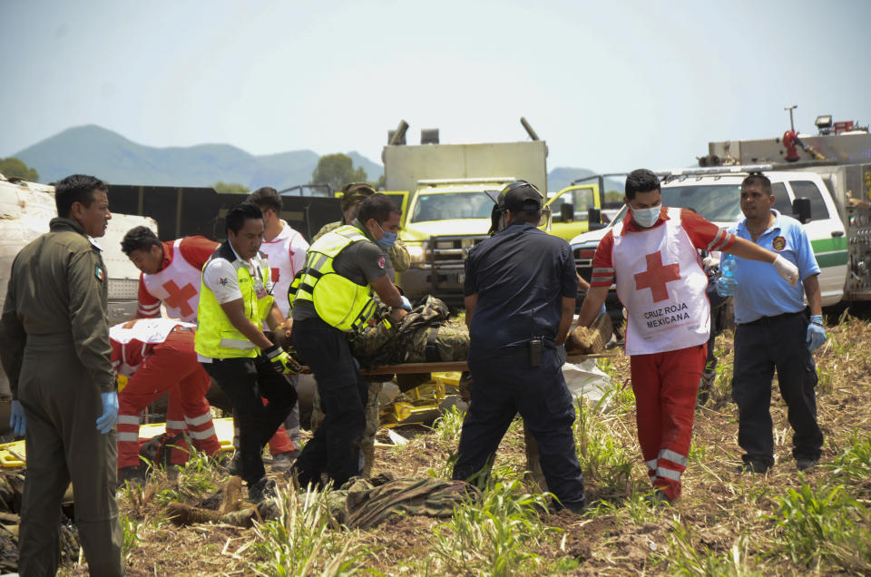 Emergency workers evacuated an injured from a navy Blackhawk helicopter crashed after supporting those who conducted the capture of drug lord Rafael Caro Quintero, near Los Mochis, Sinaloa state, Mexico, Friday, July 15, 2022. Mexico's navy said multiple people aboard died. (AP Photo/Guillermo Juarez)