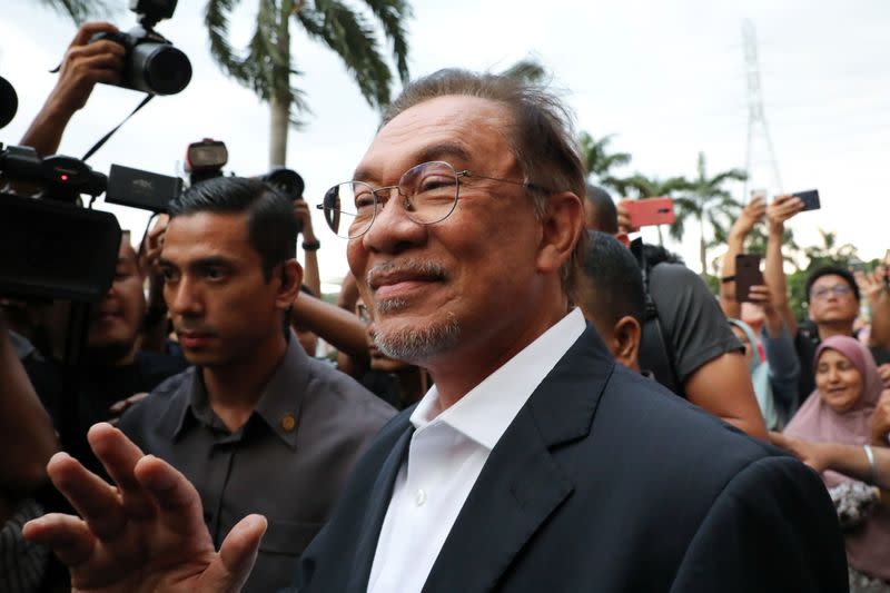 Malaysian politician Anwar Ibrahim waves to his supporters after a news conference in Petaling Jaya