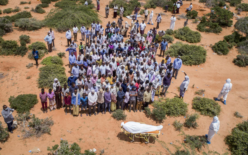 FILE - In this April 30, 2020, file photo, mourners gather to bury an elderly man believed to have died of the coronavirus but whose family asked not to be named because of the social stigma, in Mogadishu, Somalia. A dangerous stigma has sprung up around the coronavirus in Africa — fueled, in part, by severe quarantine rules in some countries as well as insufficient information about the virus. (AP Photo/File)