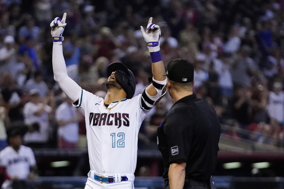 Arizona Diamondbacks' Lourdes Gurriel Jr. (12) celebrates his home run against the Cincinnati Reds as umpire Chris Segal looks on during the seventh inning of a baseball game Sunday, Aug. 27, 2023, in Phoenix. (AP Photo/Ross D. Franklin)