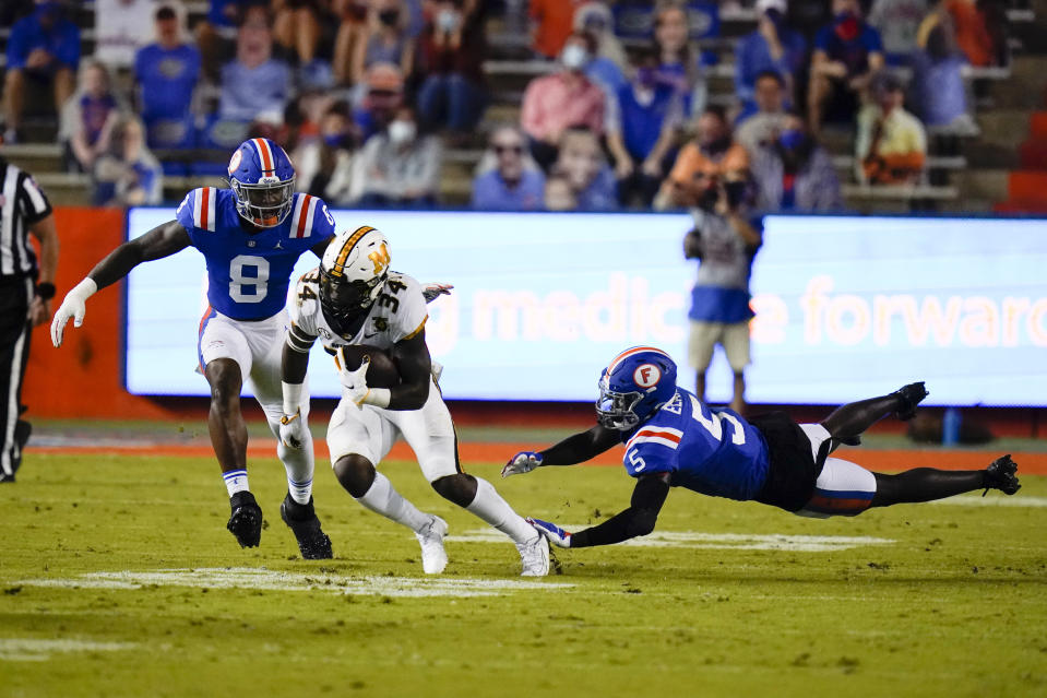 Missouri running back Larry Rountree III (34) tries to get past Florida linebacker Khris Bogle (8) and defensive back Kaiir Elam (5) during the first half of an NCAA college football game Saturday, Oct. 31, 2020, in Gainesville, Fla. (AP Photo/John Raoux)