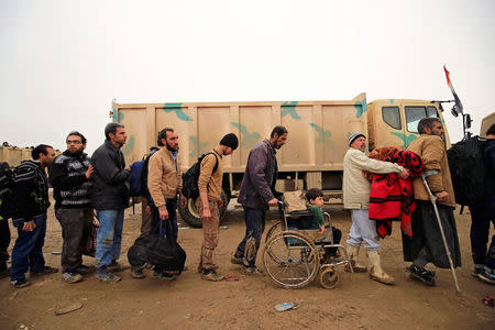 Displaced Iraqi people who fled their homes during a battle between Iraqi forces and Islamic State militants, arrive at a checkpoint to be transfer to Hammam al-Alil camp, in Mosul, Iraq, March 20, 2017. REUTERS/Thaier Al-Sudani