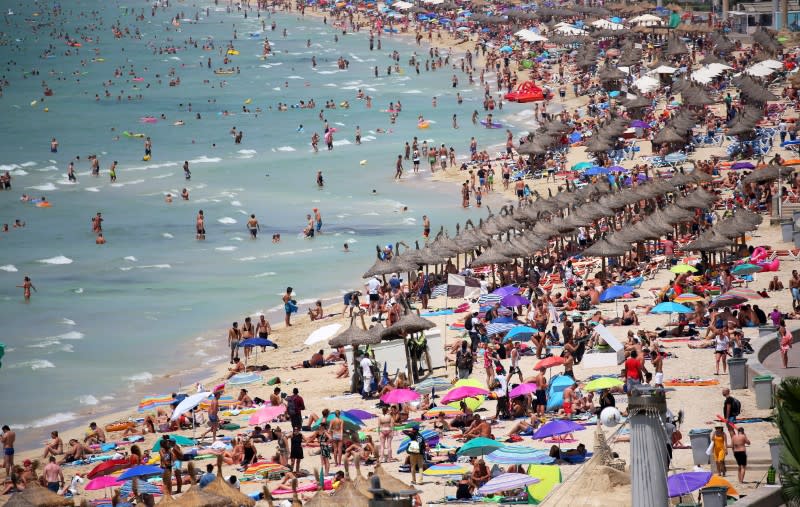 FILE PHOTO: Tourists sunbathe in El Arenal beach in the island of Mallorca