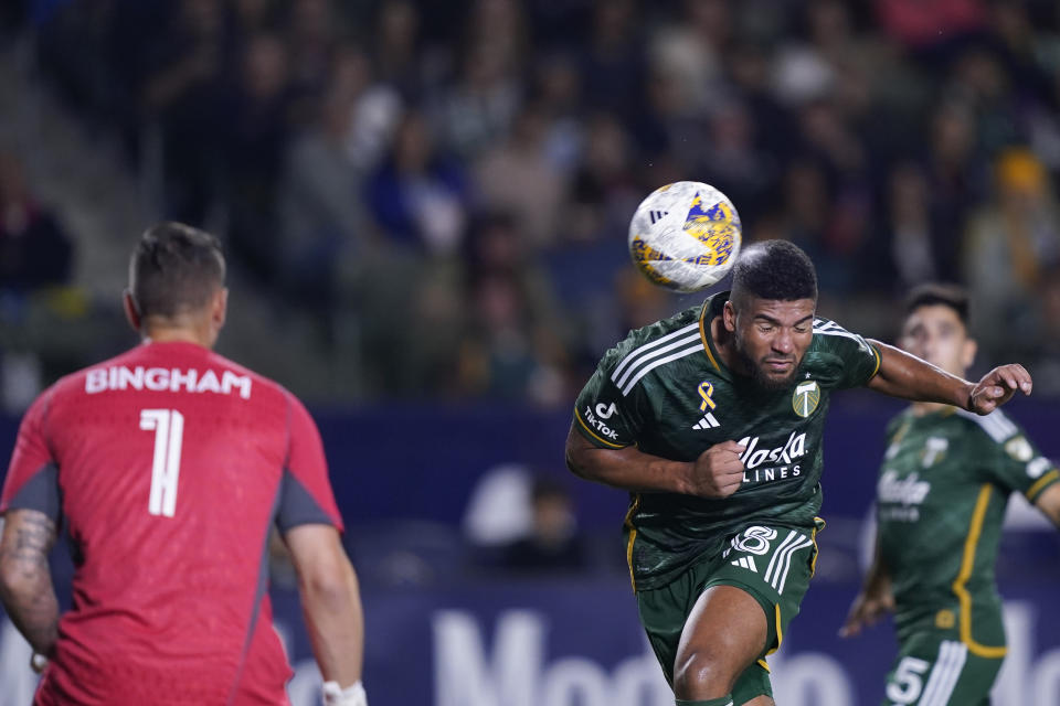 Portland Timbers defender Zac McGraw, right, heads a shot attempt away from goalkeeper David Bingham during the second half of an MLS soccer match against the LA Galaxy, Saturday, Sept. 30, 2023, in Carson, Calif. (AP Photo/Ryan Sun)