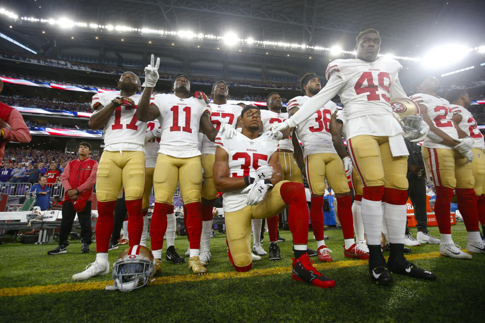 Eric Reid #35 of the San Francisco 49ers kneels during the anthem as teammates gather around him in support prior to the game against the Minnesota Vikings at U.S. Bank Stadium on August 27, 2017 in Minneapolis, Minnesota. The Vikings defeated the 49ers 32-31. (Photo by Michael Zagaris/San Francisco 49ers/Getty Images)