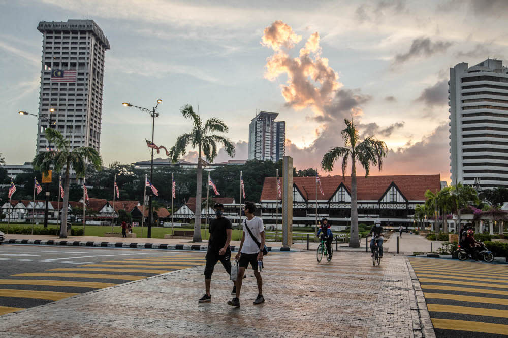 People wearing face masks walk on a street in Kuala Lumpur September 21, 2021. — Picture by Firdaus Latif