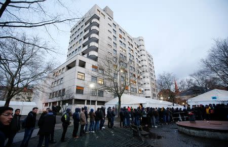 Migrants queue in front of the compound of the Berlin Office of Health and Social Affairs (LAGESO) for their registration process early morning in Berlin, Germany, February 2, 2016 REUTERS/Fabrizio Bensch