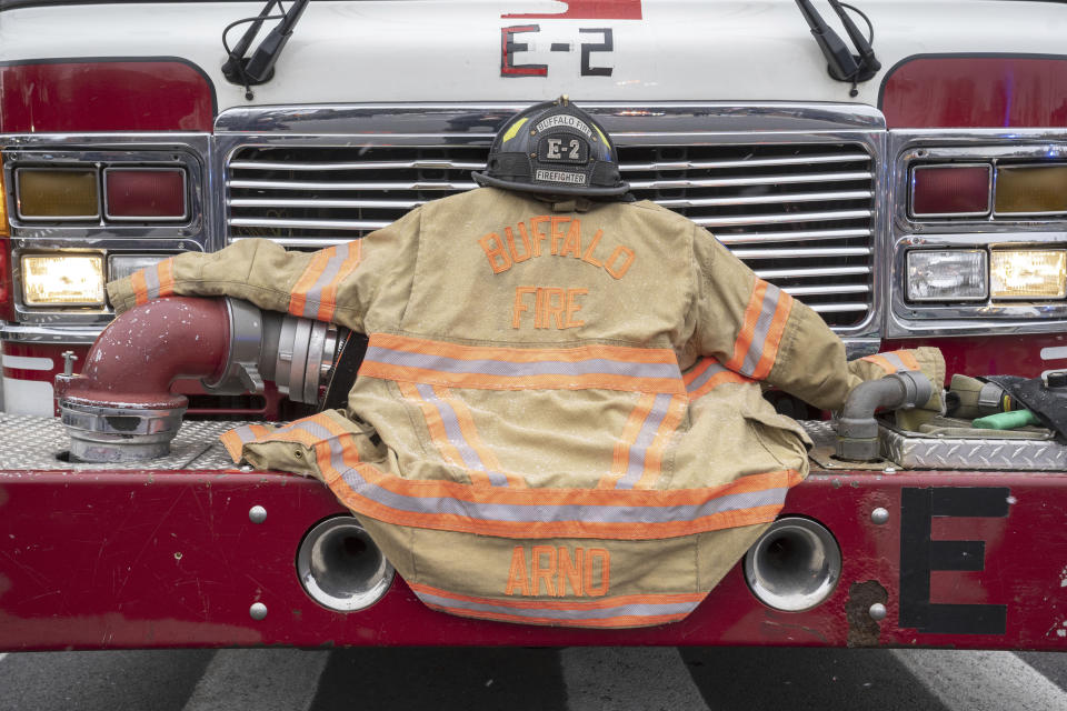 The bunker gear for Buffalo Firefighter Jason Arno is carried on the front of Engine 2 in Buffalo, N.Y., on Friday, March 10, 2023. The 37-year-old father who had been with the department for three years was killed in an explosive blaze. (Harry Scull Jr./The Buffalo News via AP)