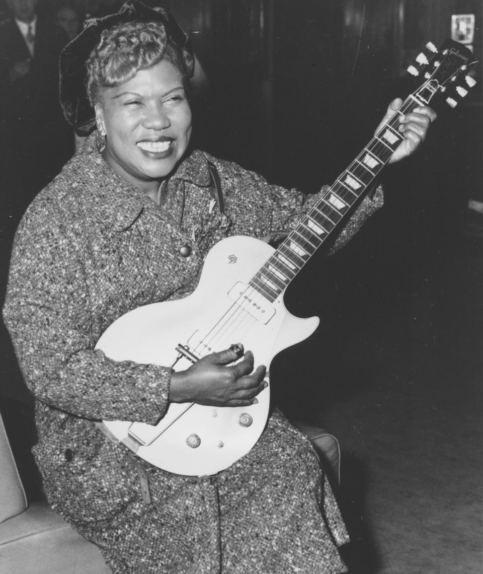 FILE- In this Nov. 21, 1957, file photo, Sister Rosetta Tharpe, guitar-playing American gospel singer, gives an inpromptu performance in a lounge at London Airport, following her arrival from New York. Tharpe, who died in 1973, will be inducted with the “Award for Early Influence" to the Rock and Roll Hall of Fame on April 14, 2018 in Cleveland, Ohio. (AP Photo, File)