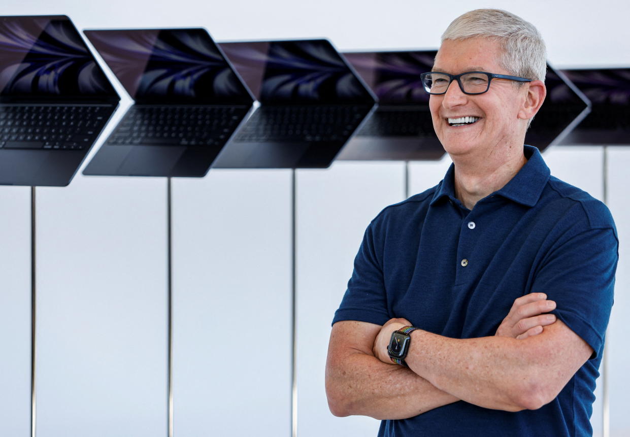 Apple CEO Tim Cook poses in front of a new MacBook Airs running M2 chips display during Apple's annual Worldwide Developers Conference in San Jose, California, U.S. June 6, 2022. REUTERS/Peter DaSilva