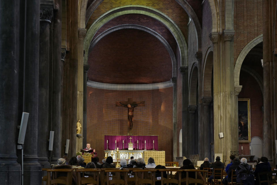 People attend a service in a church, Sunday, Nov. 29, 2020, in Lille, northern France. People in France are able to go back to their favorite shops and attend religious services after a month of partial virus lockdown, but they'll have to wait until at least Jan. 20 to savor a meal in a restaurant or enjoy a gym workout. (AP Photo/Michel Spingler)