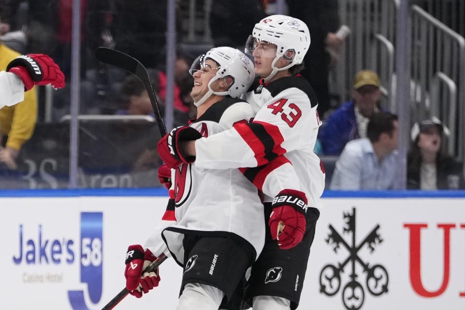 FILE - New Jersey Devils' Luke Hughes (43) hugs Jack Hughes after the overtime period of an NHL hockey game against the New York Islanders Friday, Oct. 20, 2023, in Elmont, N.Y. There are 20 sets of brothers that have played in the league this season. (AP Photo/Frank Franklin II, File)