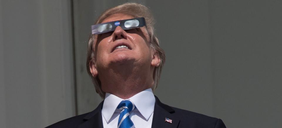 President Donald Trump looks up at the partial solar eclipse from the balcony of the White House on August 21, 2017. (Photo: AFP Contributor via Getty Images)