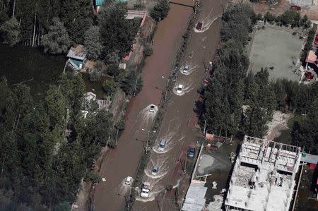 Vehicles are driven through a flooded street in Srinagar September 14, 2014. REUTERS/Adnan Abidi