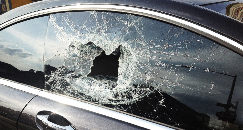 An image of a car window smashed in.