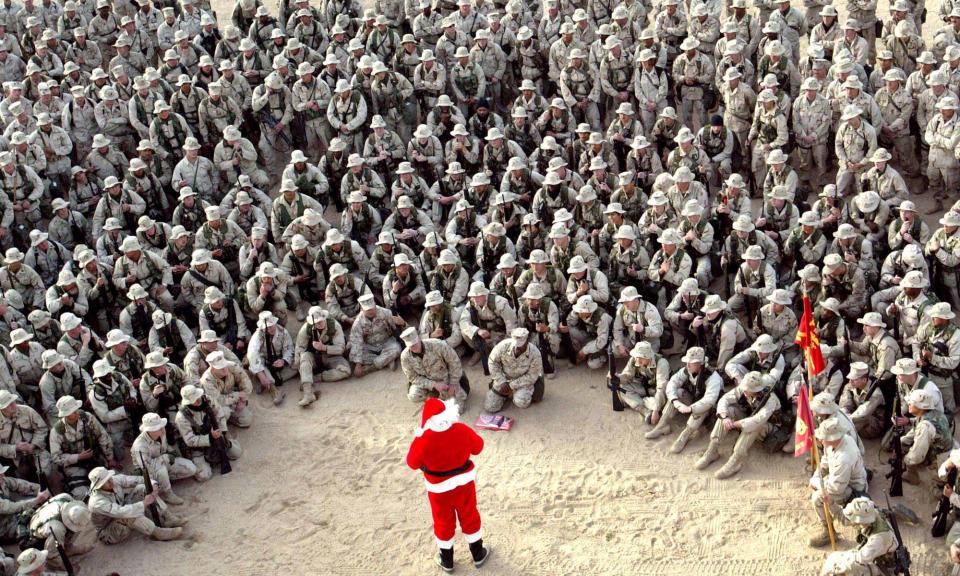 FILE - In this Tuesday, Dec. 24, 2002 file photo made by Associated Press photographer Anja Niedringhaus, hundreds of U.S. Marines gather at Camp Commando in the Kuwait desert during a Christmas eve visit by Santa Claus. Niedringhaus, 48, an internationally acclaimed German photographer, was killed and an AP reporter was wounded on Friday, April 4, 2014 when an Afghan policeman opened fire while they were sitting in their car in eastern Afghanistan. (AP Photo/Anja Niedringhaus, File)