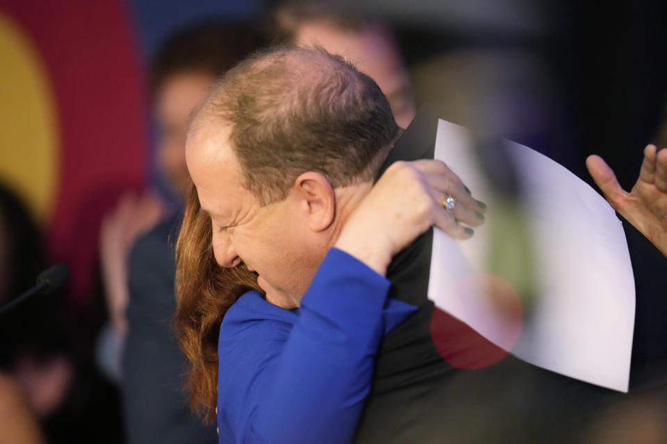 Incumbent Democratic Gov. Jared Polis, right, is hugged by Lt. Gov. Dianne Primavera during an election watch party Tuesday, Nov. 8, 2022, in downtown Denver. (AP Photo/David Zalubowski)