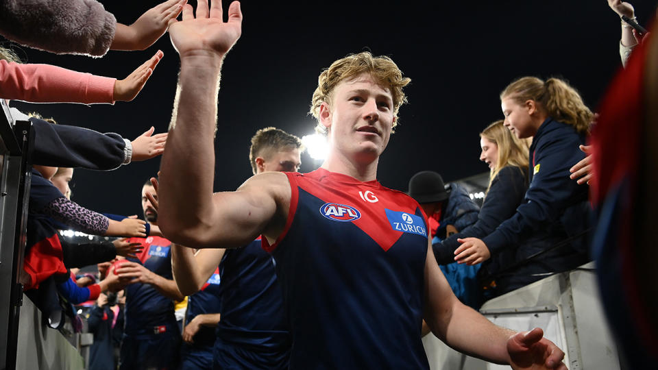 Jacob van Rooyen walks off the ground and high-fives Melbourne supporters.