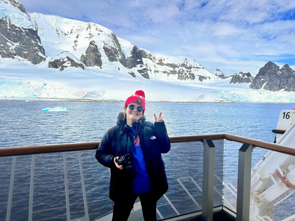 Erin Yarnall, author, smiling and putting up a peace sign in Antarctica on a cruise