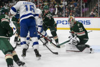 Minnesota Wild goalie Cam Talbot (33) stops a shot by Tampa Bay Lightning center Ross Colton, center left, as Wild left wing Kirill Kaprizov shoves Colton from behind during the second period of an NHL hockey game Sunday, Nov. 28, 2021, in St. Paul, Minn. (AP Photo/Craig Lassig)