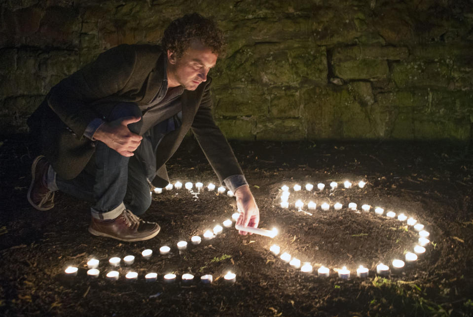 BAFTA award-winning film director Samir Mehanovic, who came to the UK as an immigrant from the Bosnian war in 1995 and now lives in Scotland, lights candles to commemorate the 25th anniversary of the Srebrenica genocide, in Edinburgh, Scotland, Thursday July 9, 2020. In July 1995, Bosnian Serb forces massacred over 8,000 men and boys, an event that is officially marked on Saturday July 10, 2020. (Jane Barlow/PA via AP)