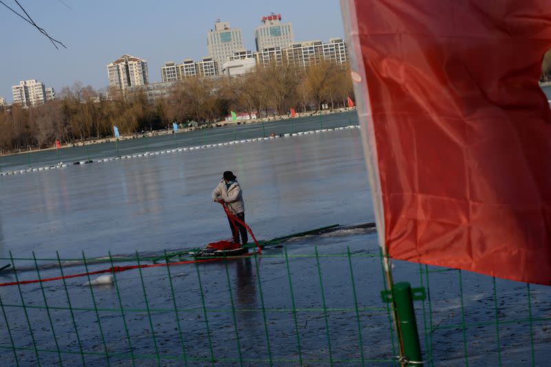 Worker dismantles a closed ice rink on a frozen lake at the Yuyuantan Park, as the country is hit by an outbreak of the new coronavirus, in Beijing