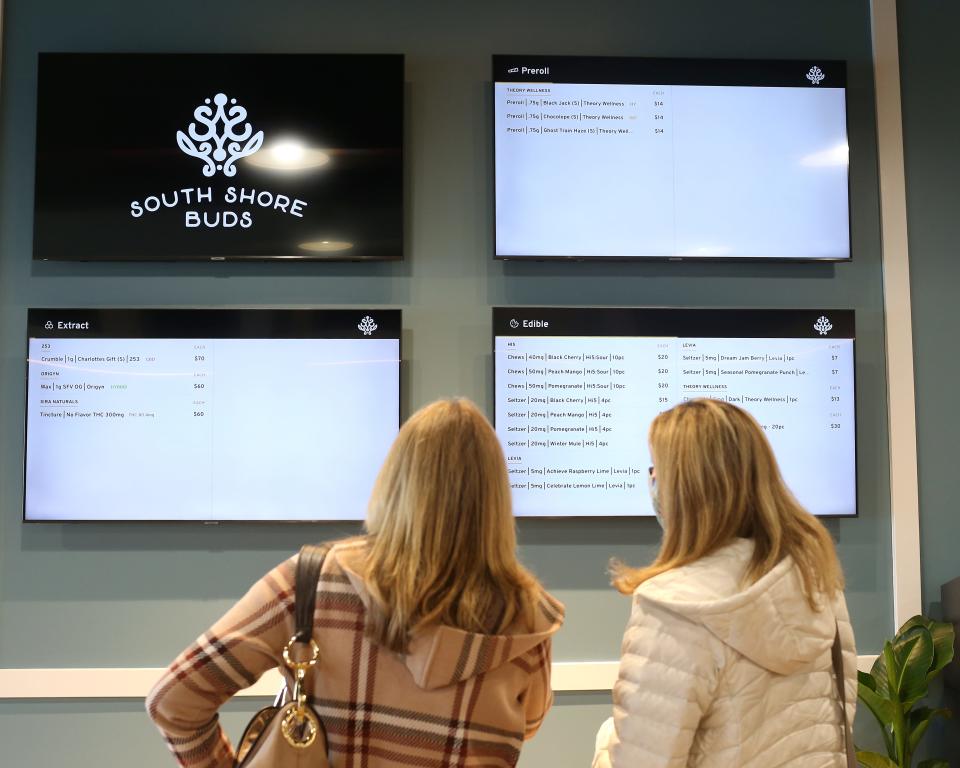 Two women check out the menu at the opening for VIPs at South Shore Buds in Marshfield on Wednesday, Dec. 15, 2021.