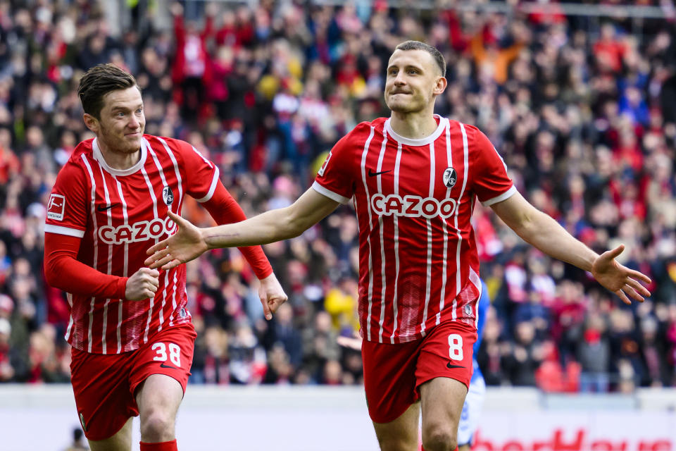 Freiburg's Maximilian Eggestein, right, celebrates with Freiburg's Michael Gregoritsch after his goal for 1:0 during the German Bundesliga soccer match between TSG 1899 Hoffenheim and SC Freiburg in Freiburg im Breisgau, Germany, Sunday March 12, 2023. (Tom Weller/dpa via AP)