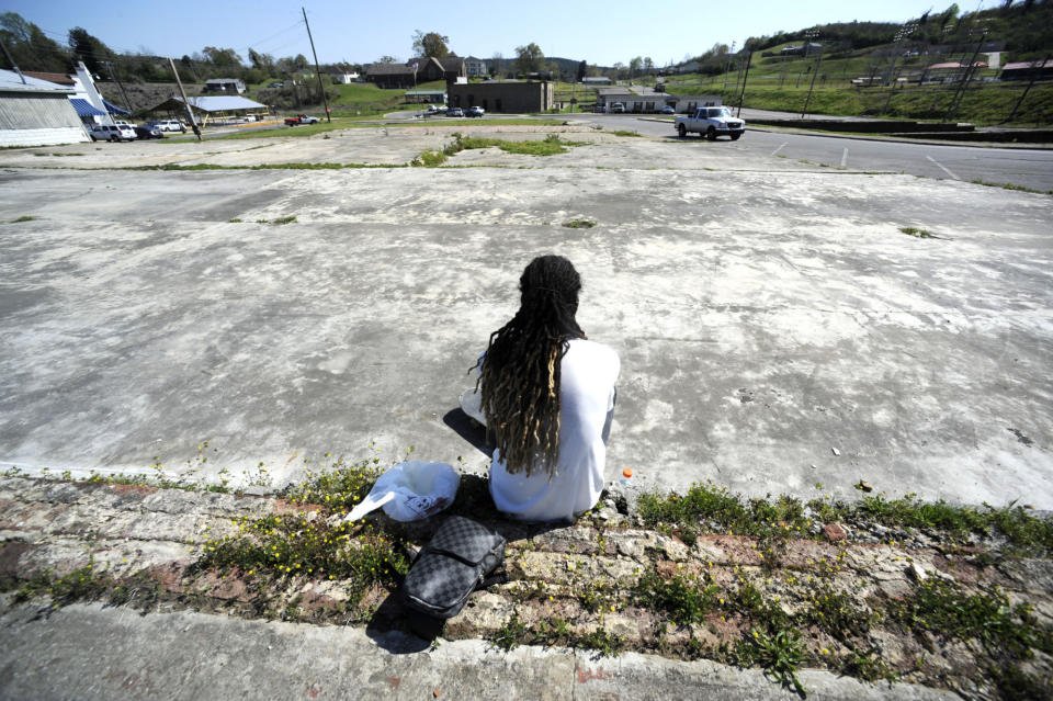 Austin Thomas is shown on Monday, April 5, 2021, in Corodova, Ala., sitting on weedy building foundations that remain a decade after a tornado badly damaged the town's downtown on April 27, 2011. Events are being held in some cities to mark the 10th anniversary of the tornado outbreak, which killed more than 250 people statewide. (AP Photo/Jay Reeves)