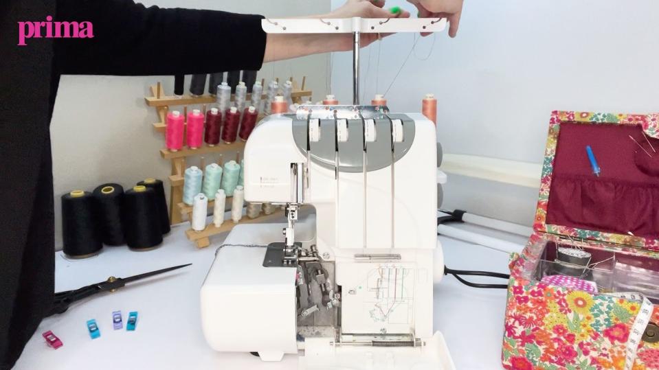 a person threading an overlocker sewing machine