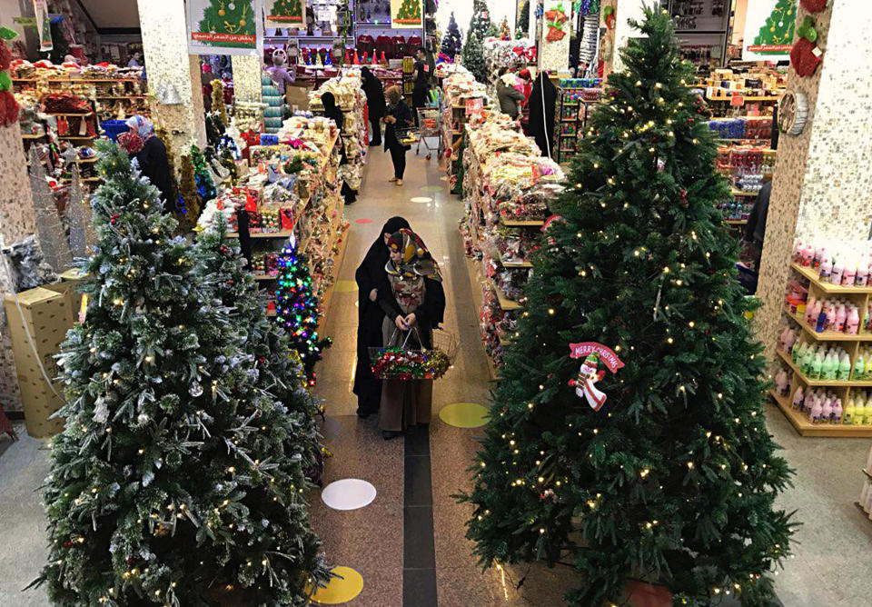 Iraqis shop for Christmas decorations in Baghdad, Iraq, Monday, Dec. 24, 2018. Although the number of Christians has dropped in Iraq, Christmas, a national holiday in Iraq, is very popular in the capital. (AP Photo/Ali Abdul Hassan)