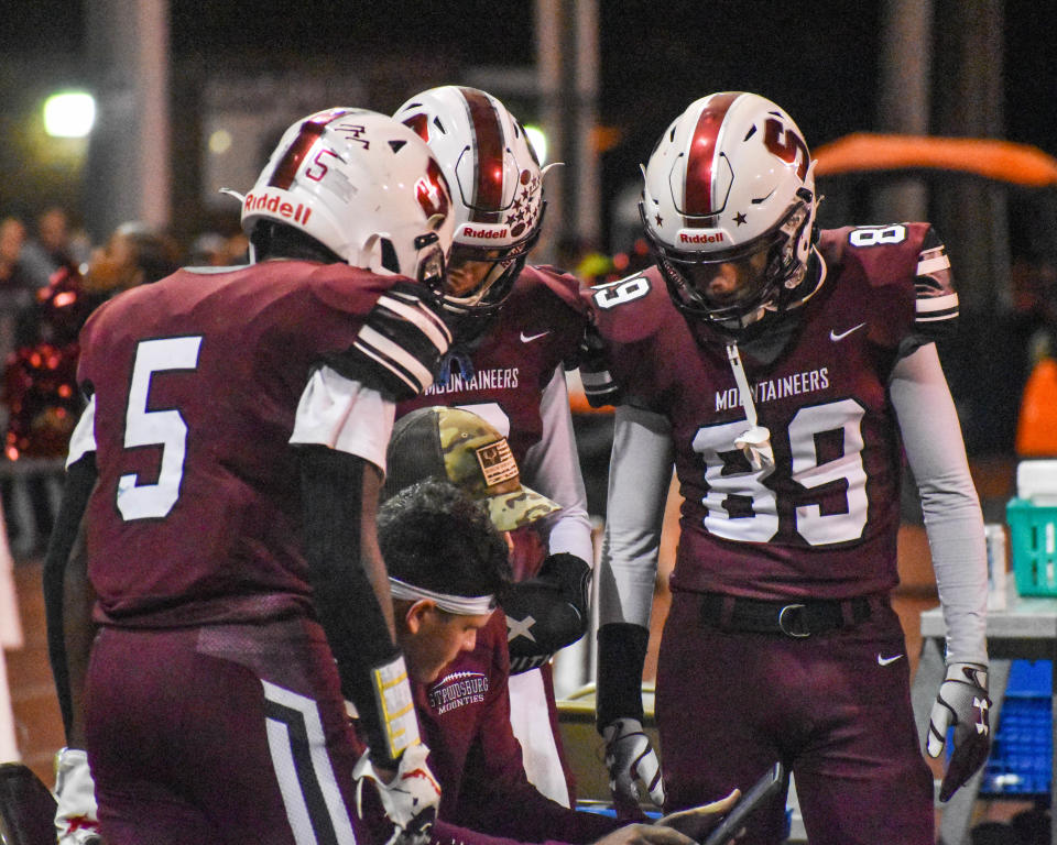 Stroudsburg football players review notes with an assistant coach during their game against Pocono Mountain West in Stroudsburg on Friday, Sept. 24, 2021. West won in overtime, 9-3.
