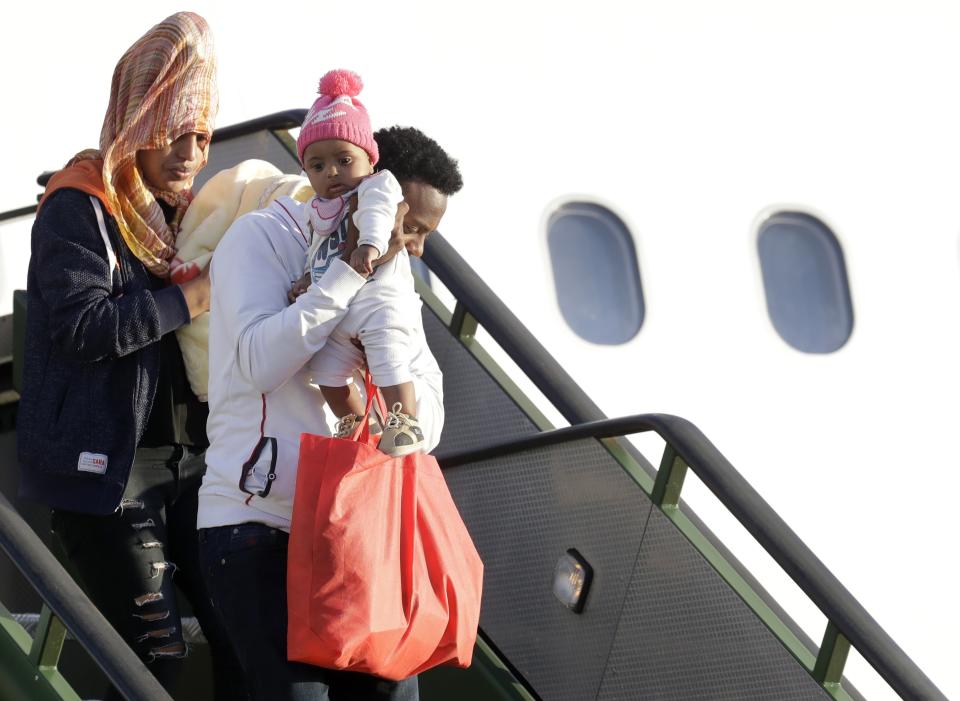 A family with a baby disembarks from an Italian military aircraft arriving from Misrata, Libya, at Pratica di Mare military airport, near Rome, Monday, April 29, 2019. Italy organized a humanitarian evacuation airlift for a group of 147 asylum seekers from Ethiopia, Eritrea, Somalia, Sudan and Syria. (AP Photo/Andrew Medichini)