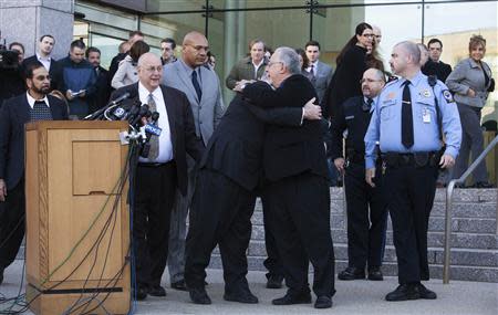Michael Skakel (centre L) is embraced by an unidentified man near his attorney Hubert Santos (2nd L), as he leaves Superior Court after posting a $1.2 million bail in Stamford, Connecticut November 21, 2013. REUTERS/Michelle McLoughlin