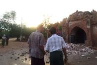 Two men look at a collapsed entrance of a pagoda after an earthquake in Bagan, Myanmar August 24, 2016. REUTERS/Surapan Boonthanom