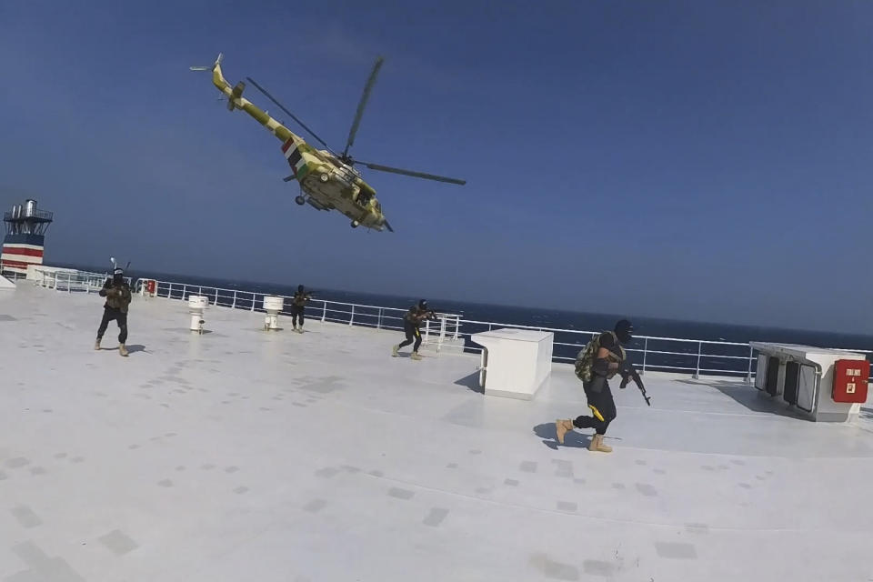 This photo released by the Houthi Media Center shows Houthi forces boarding the cargo ship Galaxy Leader on Sunday, Nov. 19, 2023. Yemen's Houthis have seized the ship in the Red Sea off the coast of Yemen after threatening to seize all vessels owned by Israeli companies. (Houthi Media Center via AP)