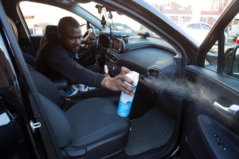 Uber and Lyft driver Adama Fofana, who says he and other drivers he knows have "fear in their stomachs" about contracting the coronavirus disease (COVID-19) while working, but cannot cut their hours because they need the income to survive, sprays disinfectant in his car in New York City, New York, U.S., March 9, 2020. Picture taken March 9, 2020. REUTERS/Joe Penney