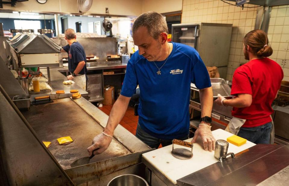 Store manager Calvin Ferguson preps a HiBoy double cheeseburger on a recent afternoon. HiBoy uses lean 90/10% meat from L&C Meat, an Independence butcher that dates back to 1948.