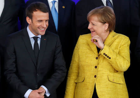 French President Emmanuel Macron and German Chancellor Angela Merkel take part in a group photo on the launching of the Permanent Structured Cooperation, or PESCO, a pact between 25 EU governments to fund, develop and deploy armed forces together, during a EU summit in Brussels, Belgium, December 14, 2017. REUTERS/Yves Herman